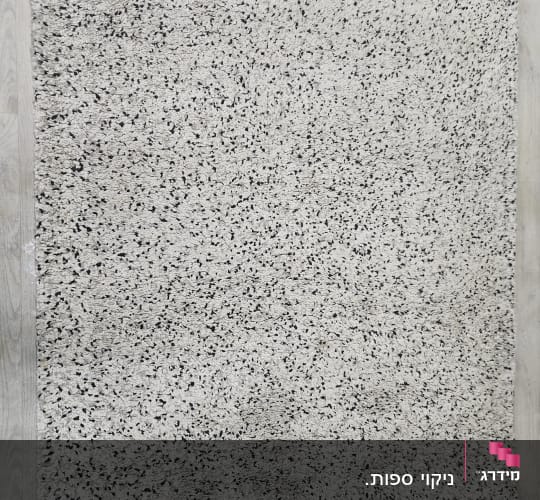 שטיח אפור עם נקודות שחורות על רצפה בהירה